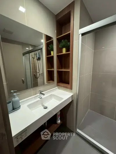 Modern bathroom with sleek shower and stylish vanity in contemporary design.