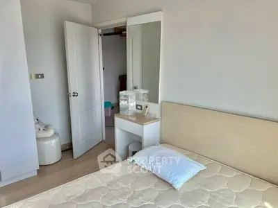Cozy bedroom with minimalist decor and natural light, featuring a comfortable bed and stylish vanity.