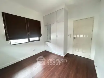 Spacious bedroom with wooden flooring and built-in wardrobe, perfect for modern living.