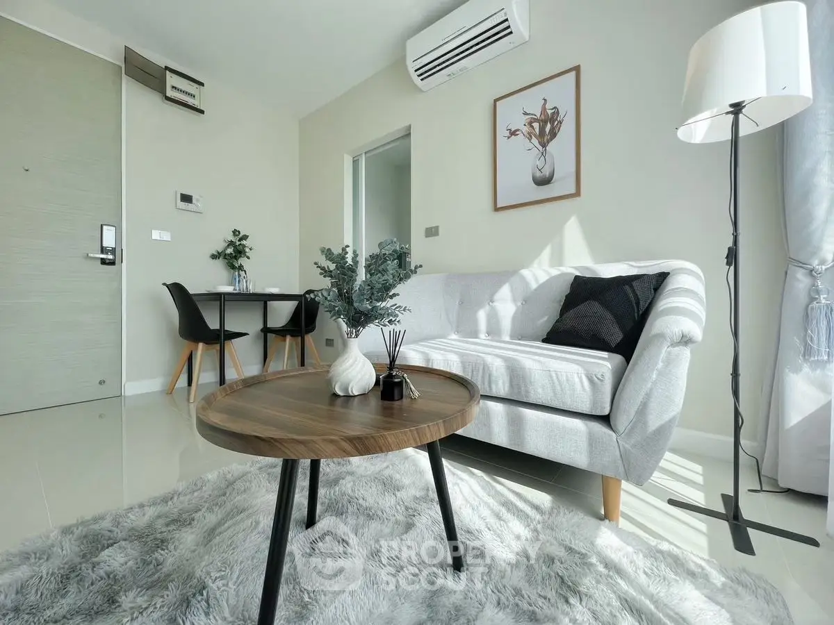 Modern living room with stylish decor and natural light, featuring a cozy sofa and elegant coffee table.