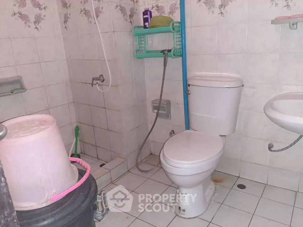 Functional bathroom with essential fixtures and tiled walls, ideal for practical living.