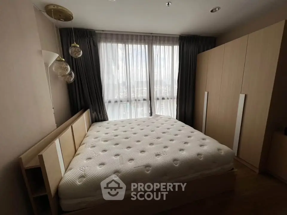 Cozy bedroom with large windows and modern wardrobe, perfect for relaxation.