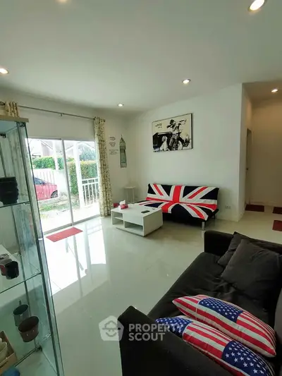 Bright living room with modern decor and large sliding glass doors opening to garden view.