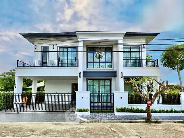Stunning modern two-story house with large windows and elegant balcony in a serene neighborhood.