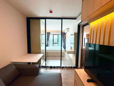 Modern studio apartment with open layout and city view, featuring sleek furniture and ample natural light.