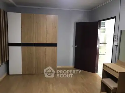 Spacious bedroom with modern wardrobe and wooden flooring