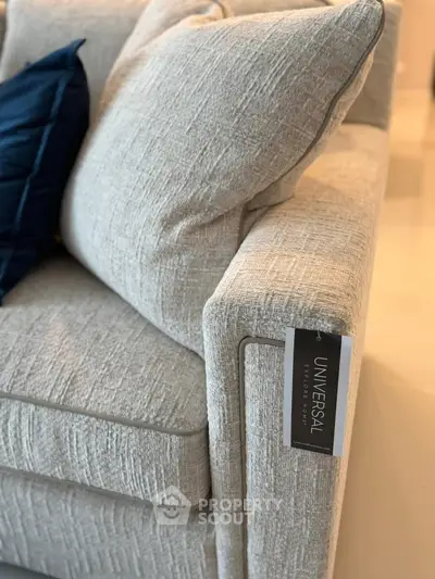 Elegant modern sofa with textured fabric and plush cushions in a stylish living room setting.