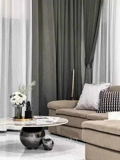 Elegant living room with plush sofa, chic decor, and stylish curtains.