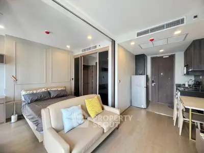Modern studio apartment with open layout, featuring a cozy living area and compact kitchen.