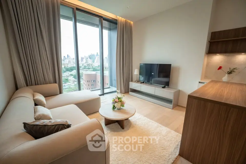 Modern living room with city view, featuring cozy sofa and sleek TV setup.
