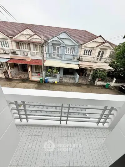 Charming balcony view of quaint residential street with colorful townhouses.