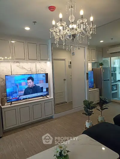Luxurious living room with chandelier and modern kitchen in open layout apartment.