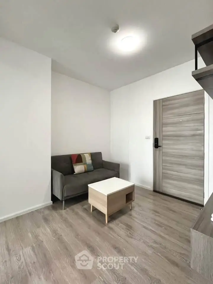 Modern minimalist living room with sleek wooden flooring and cozy sofa