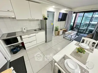 Modern open-layout kitchen and living area with balcony view in stylish apartment.