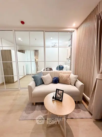 Modern living room with elegant decor and glass partition, featuring cozy sofa and stylish coffee table.