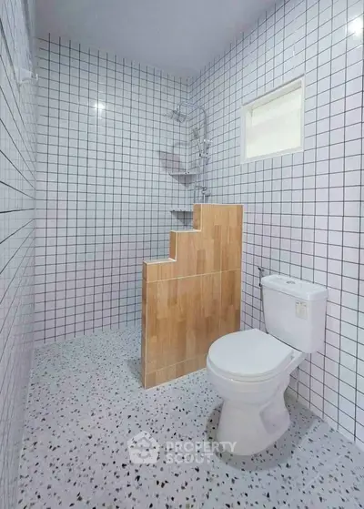 Modern bathroom with unique tile design and compact layout