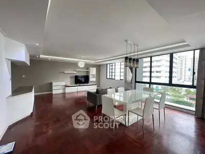 Spacious modern living room with elegant dining area and large windows offering city views.
