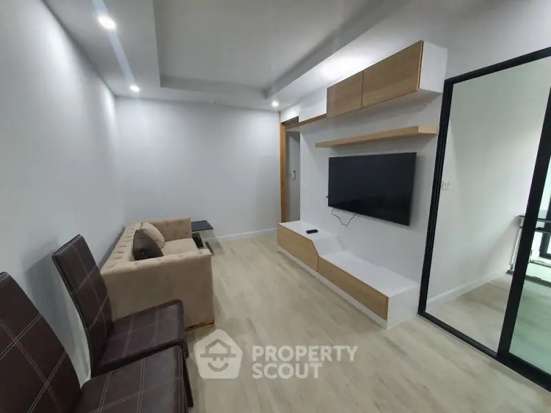 Modern living room with sleek design, featuring a wall-mounted TV and stylish furniture.