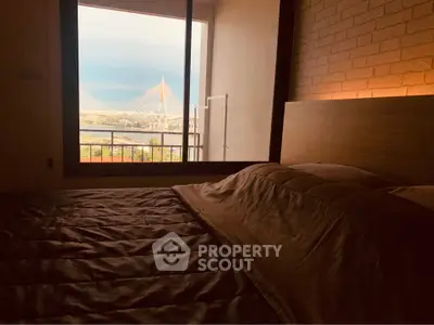 Cozy bedroom with stunning bridge view through large window, perfect for relaxation and comfort.