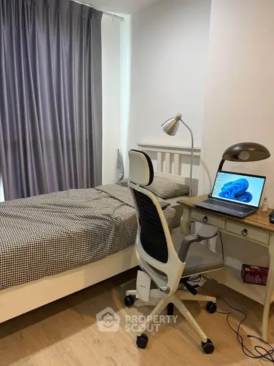 Cozy bedroom with study area featuring a comfortable bed and modern desk setup.