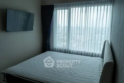 Modern bedroom with large window and wall-mounted TV, offering a serene city view.