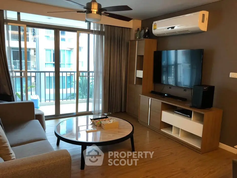 Modern living room with large window, stylish furniture, and air conditioning in a contemporary apartment.