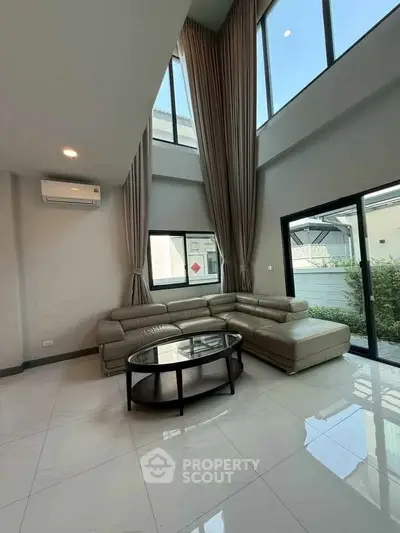 Spacious modern living room with high ceilings and large windows for natural light.