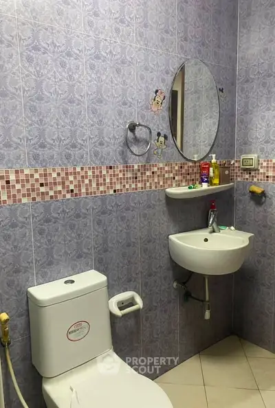 Charming bathroom with unique tile design and modern fixtures, ideal for a cozy home.
