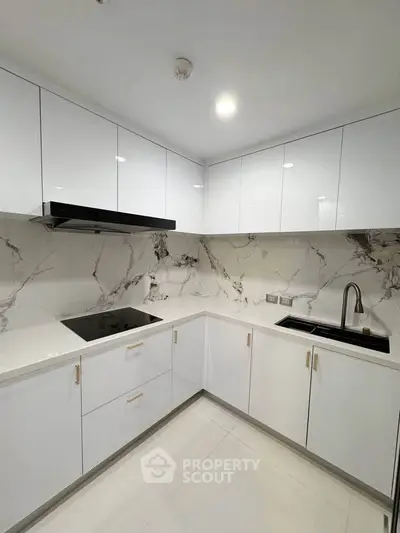 Modern kitchen with sleek white cabinets and marble backsplash