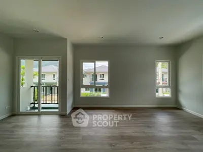 Spacious empty living room with large windows and balcony view