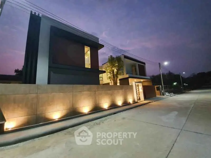 Modern luxury home exterior with elegant lighting at dusk, showcasing contemporary architectural design.