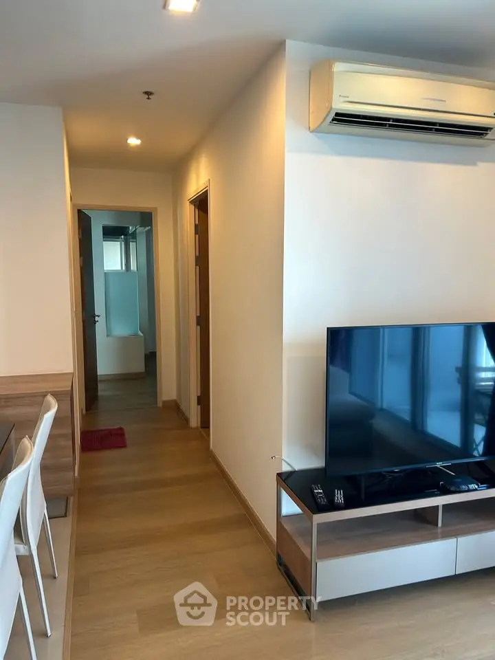 Modern living room with sleek TV setup and air conditioning in a cozy apartment.