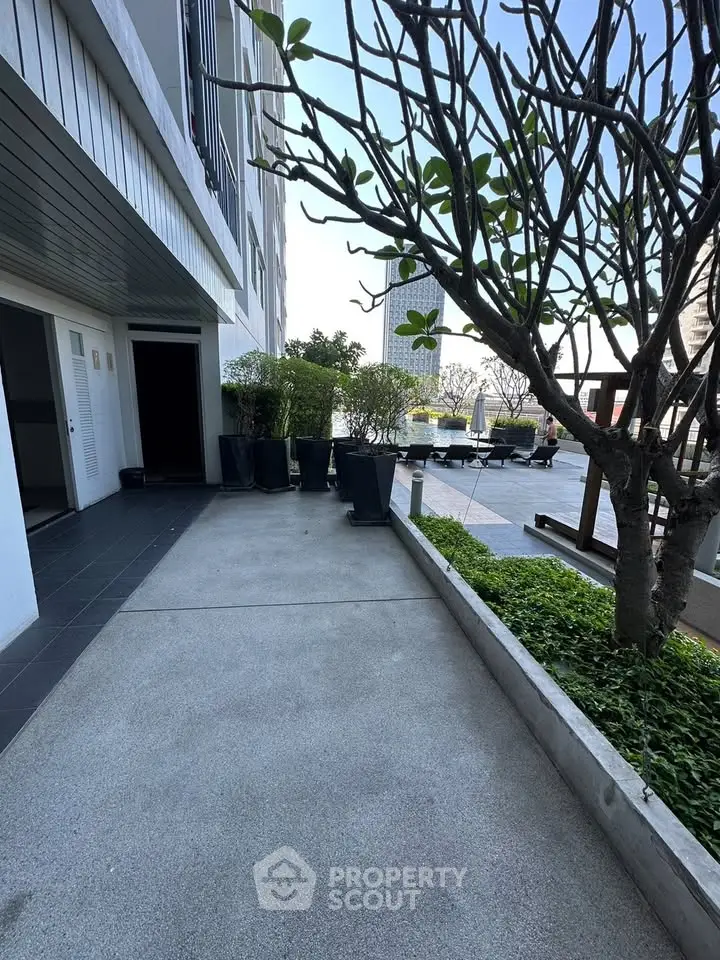 Modern building exterior with landscaped garden and outdoor seating area, perfect for relaxation.