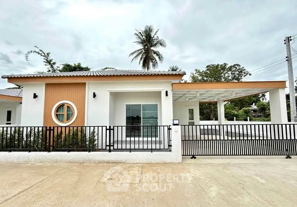 Modern single-story house with unique circular window and spacious driveway.