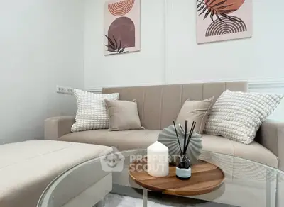 Stylish modern living room with beige sofa, decorative pillows, and chic wall art.