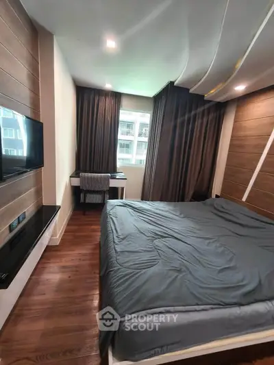 Modern bedroom with wooden flooring and stylish decor in a high-rise apartment.