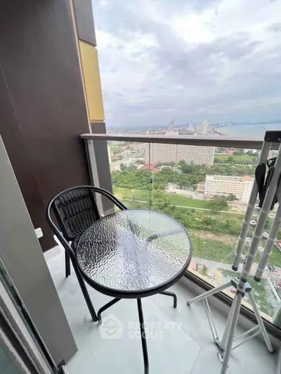 Stunning high-rise balcony with glass table and panoramic city view