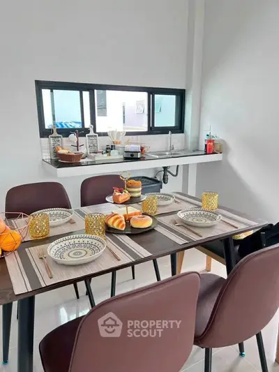 Modern dining area with stylish table setting and open kitchen layout
