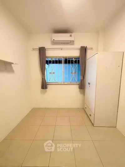 Minimalist bedroom with air conditioning and wardrobe, ideal for cozy living.