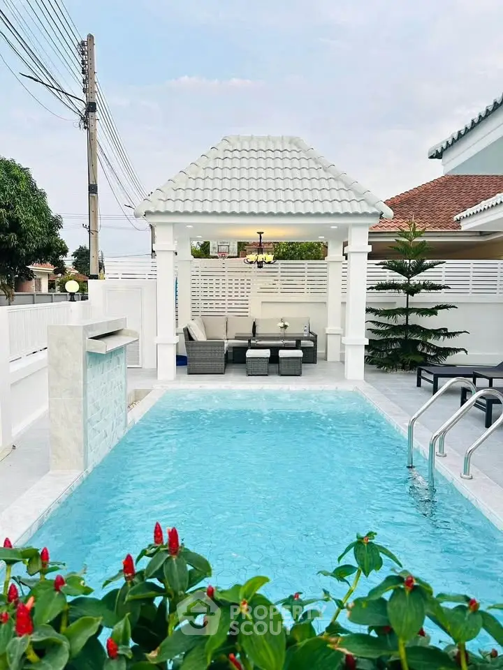 Charming backyard with a pristine pool and cozy seating area, perfect for relaxation and entertainment.
