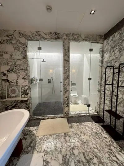 Luxurious marble bathroom with glass shower and freestanding bathtub
