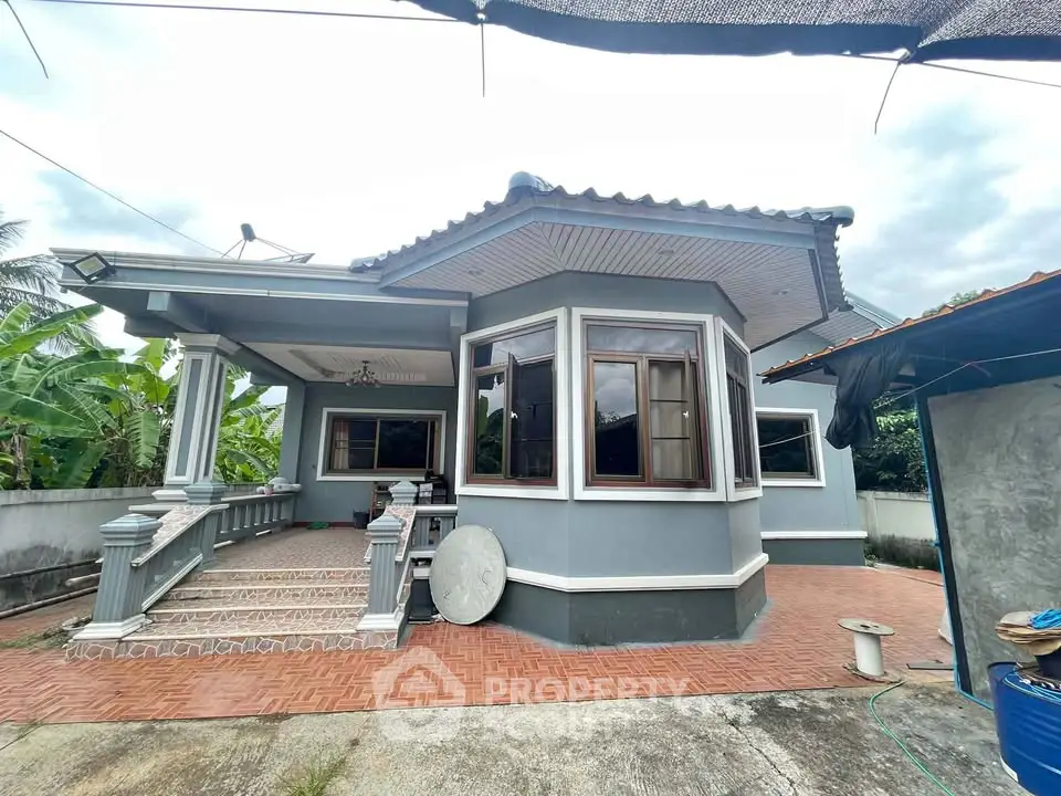 Charming single-story home with spacious patio and lush greenery, perfect for serene living.