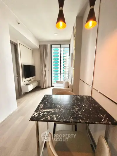 Modern living room with stylish decor and city view, featuring elegant lighting and sleek furniture.