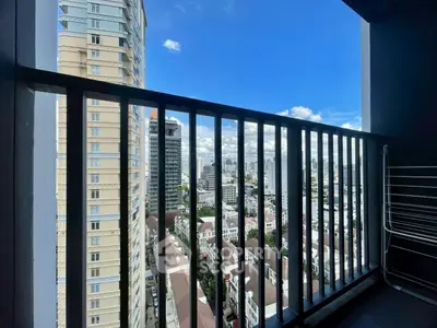 Stunning cityscape view from a high-rise balcony with clear blue skies.