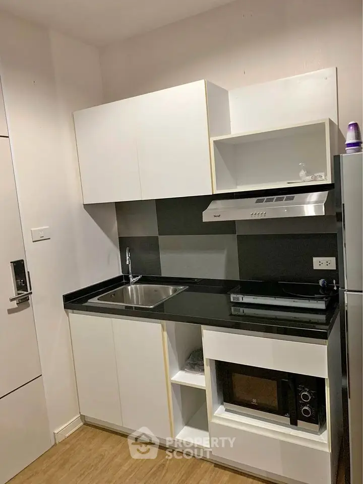 Modern compact kitchen with sleek black countertop and built-in appliances