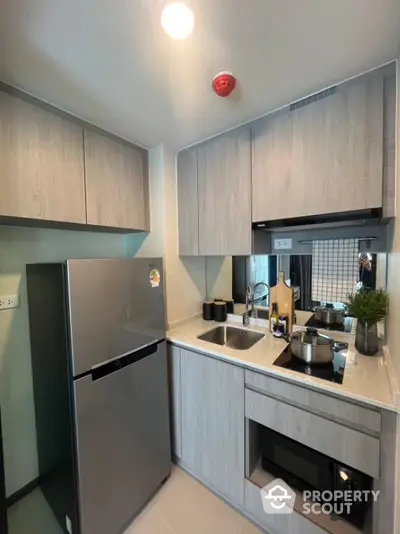 Modern compact kitchen with sleek cabinetry and stainless steel appliances