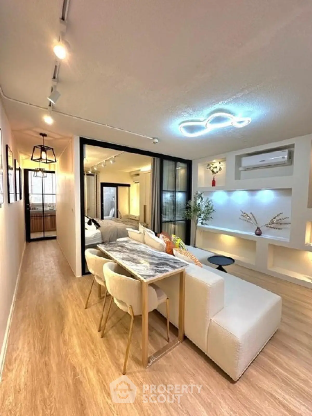 Modern living room with stylish lighting and open layout, featuring a cozy dining area and elegant decor.
