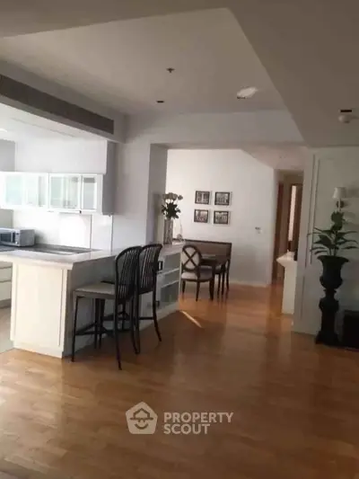 Spacious open-plan kitchen and dining area with modern decor and hardwood floors.