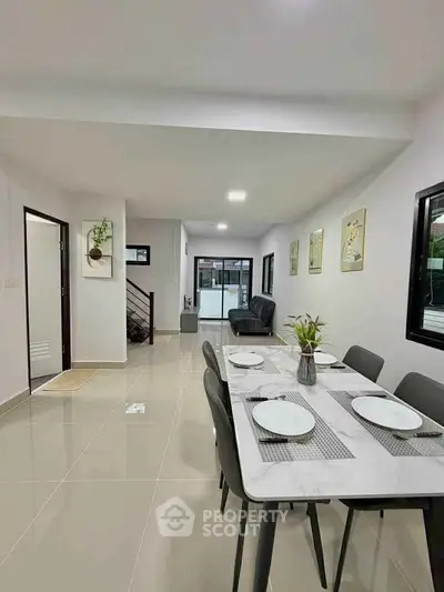 Spacious modern dining area with elegant decor and natural light, perfect for family gatherings.