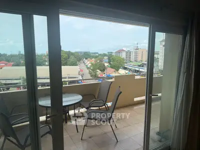 Spacious balcony with outdoor seating offering a vibrant city view, perfect for relaxation and entertainment.